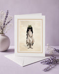 Blank art greeting card with envelope featuring a gothic Victorian girl holding baby blackbirds, styled next to a vase of dried flowers.