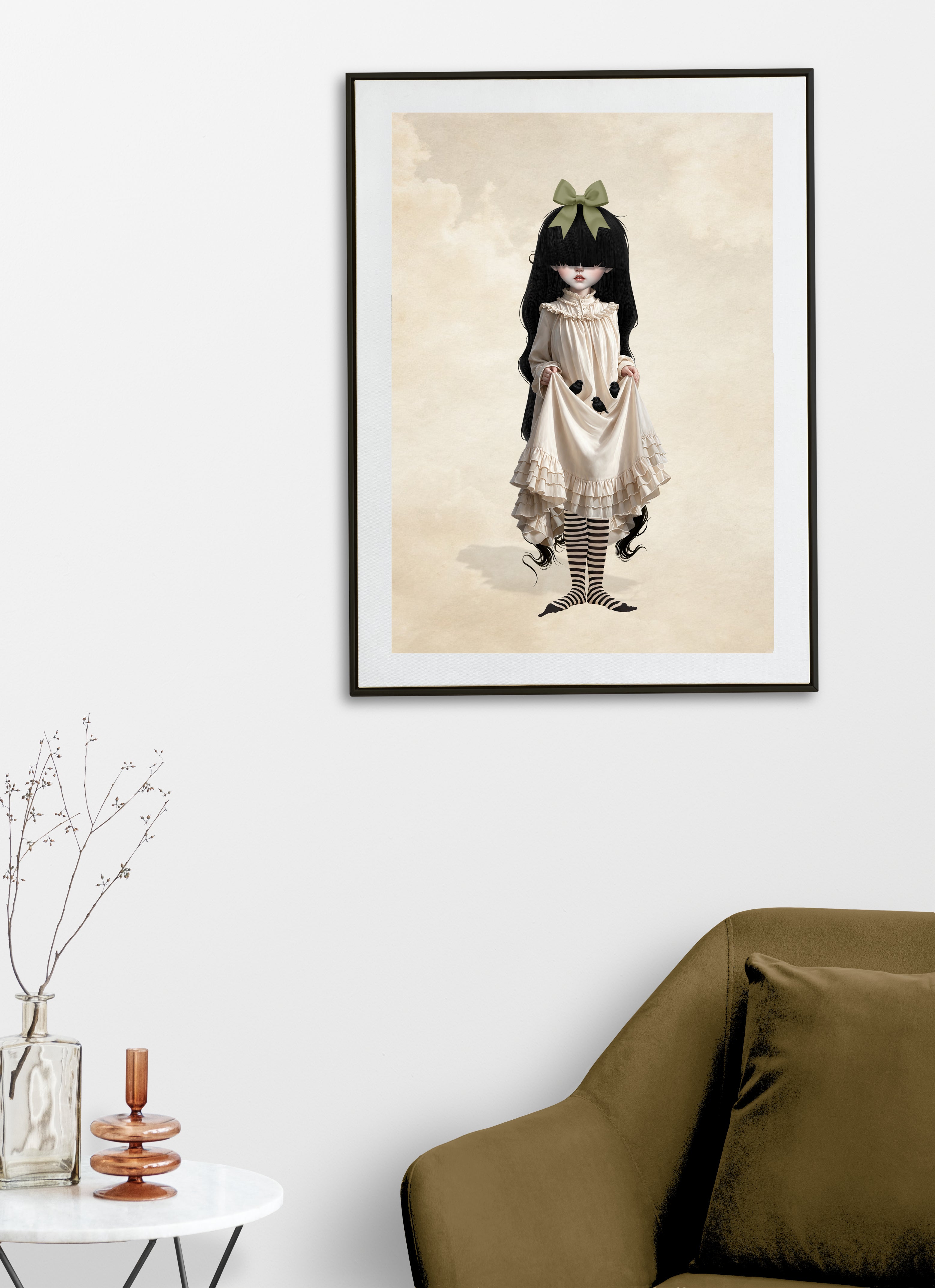 Framed art print displayed on a living room wall featuring gothic girl with long black hair, a green hair bow, and a cream ruffled Victorian dress holding three baby blackbirds in her skirt fold.