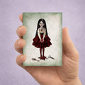 ACEO art card held in hand featuring a gothic girl holding a bleeding anatomical heart with a broken mirror at her feet.