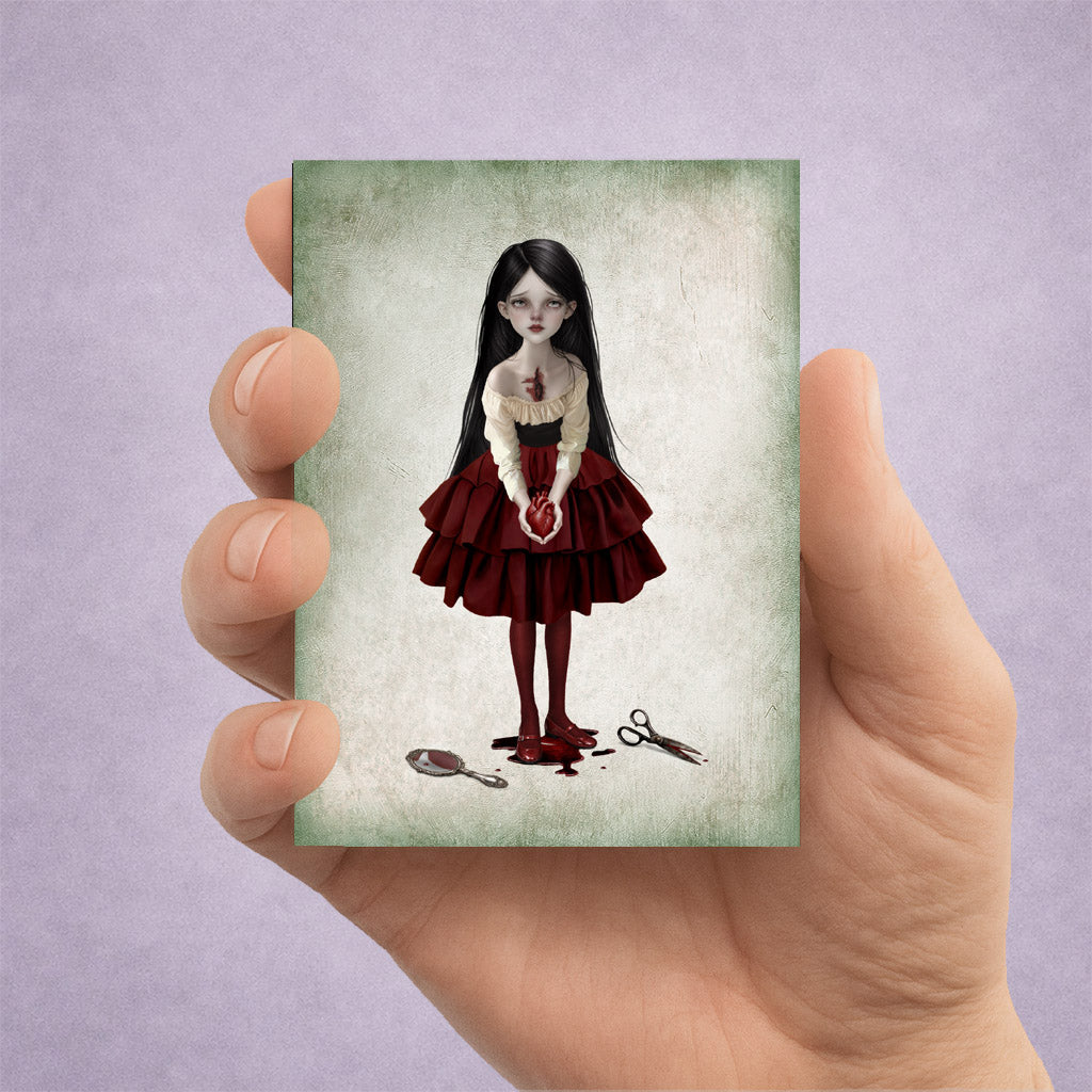 ACEO art card held in hand featuring a gothic girl holding a bleeding anatomical heart with a broken mirror at her feet.