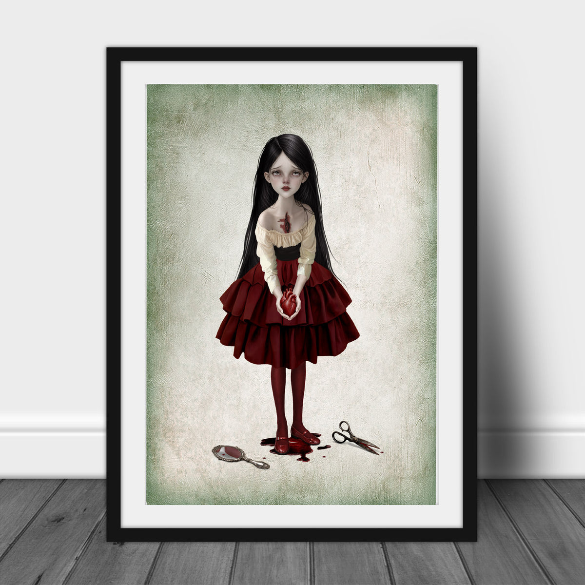 Gothic dark romance fine art print in an A3 Frame featuring a girl holding a bleeding anatomical heart near a broken mirror and scissors on a soft green background.
