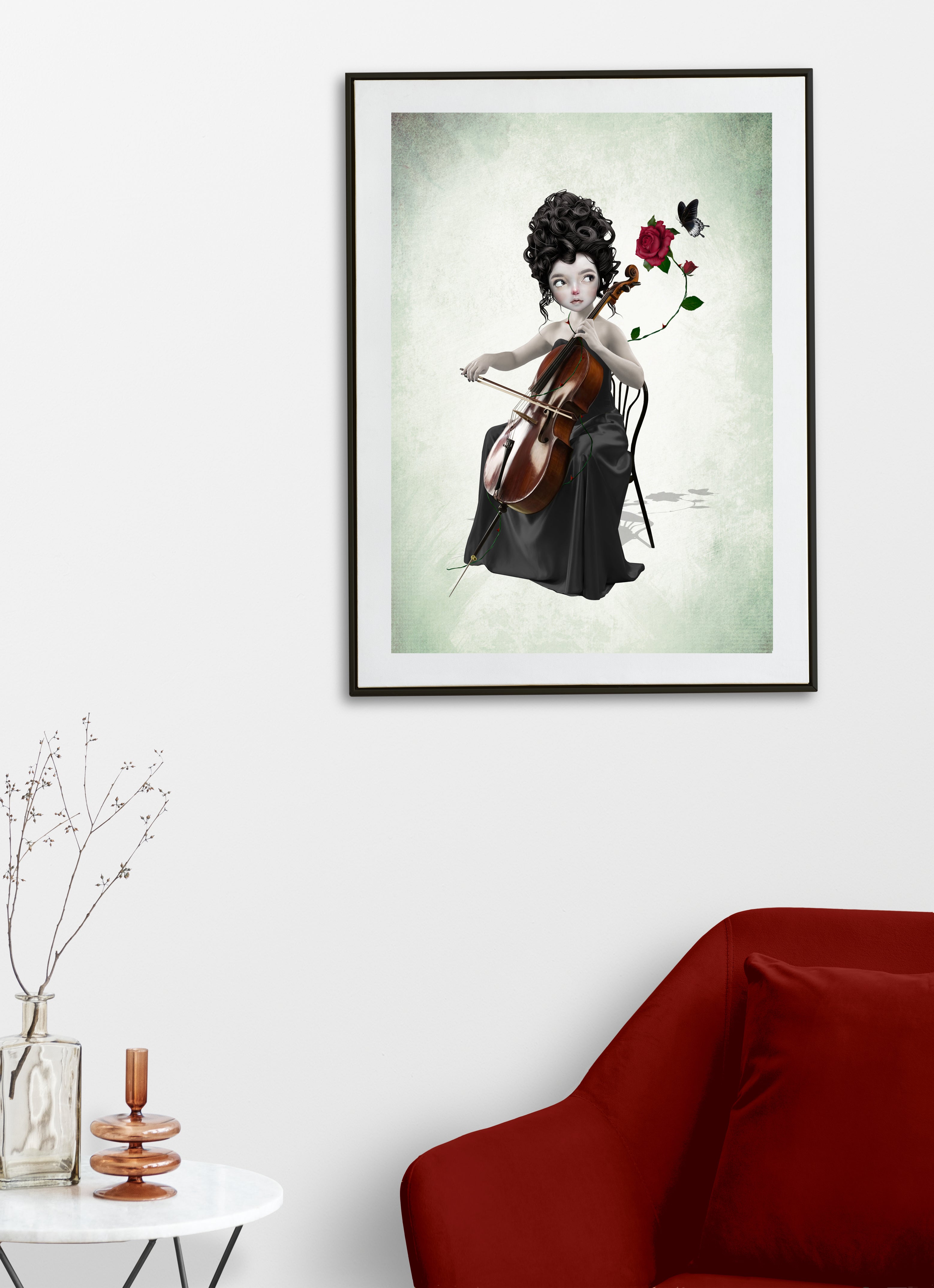 Framed artwork of a woman playing a cello with flowers on a white wall above a red sofa.