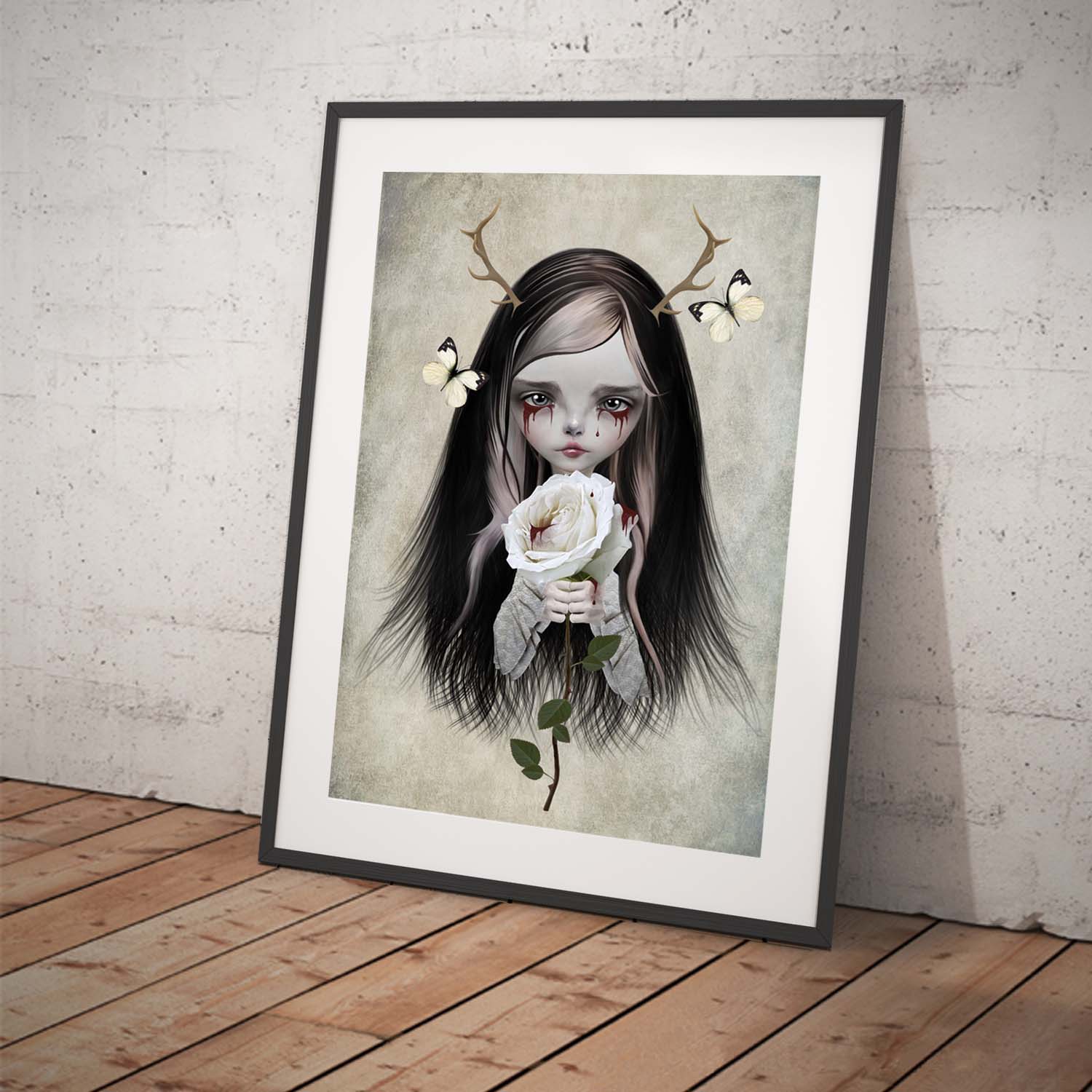 Framed gothic fantasy art print of antlered girl with bleeding eyes, clutching a white bloody rose.