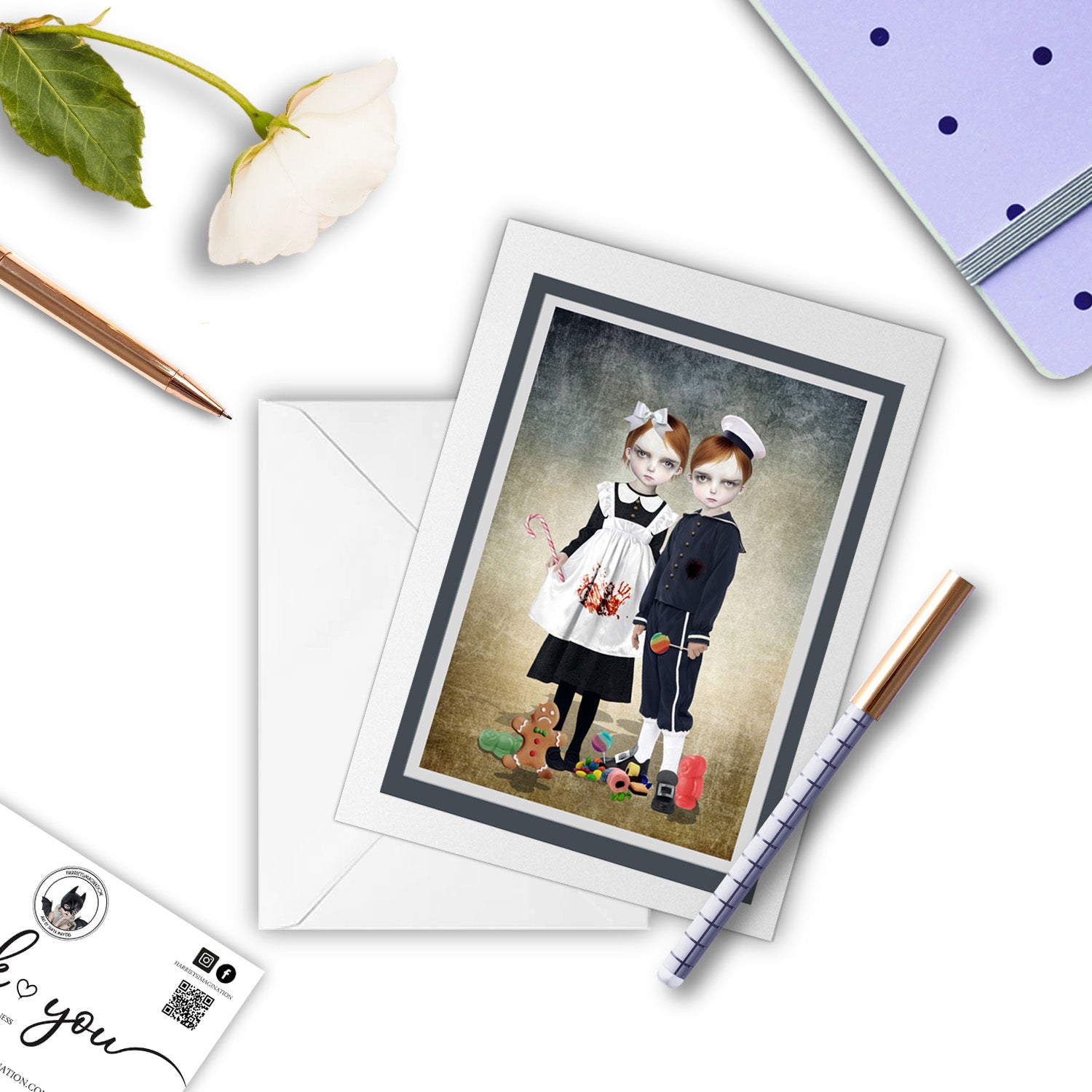 Gothic Fairytale Hansel & Gretel Art Greeting Card, with a pen and other stationary items arranged around it.