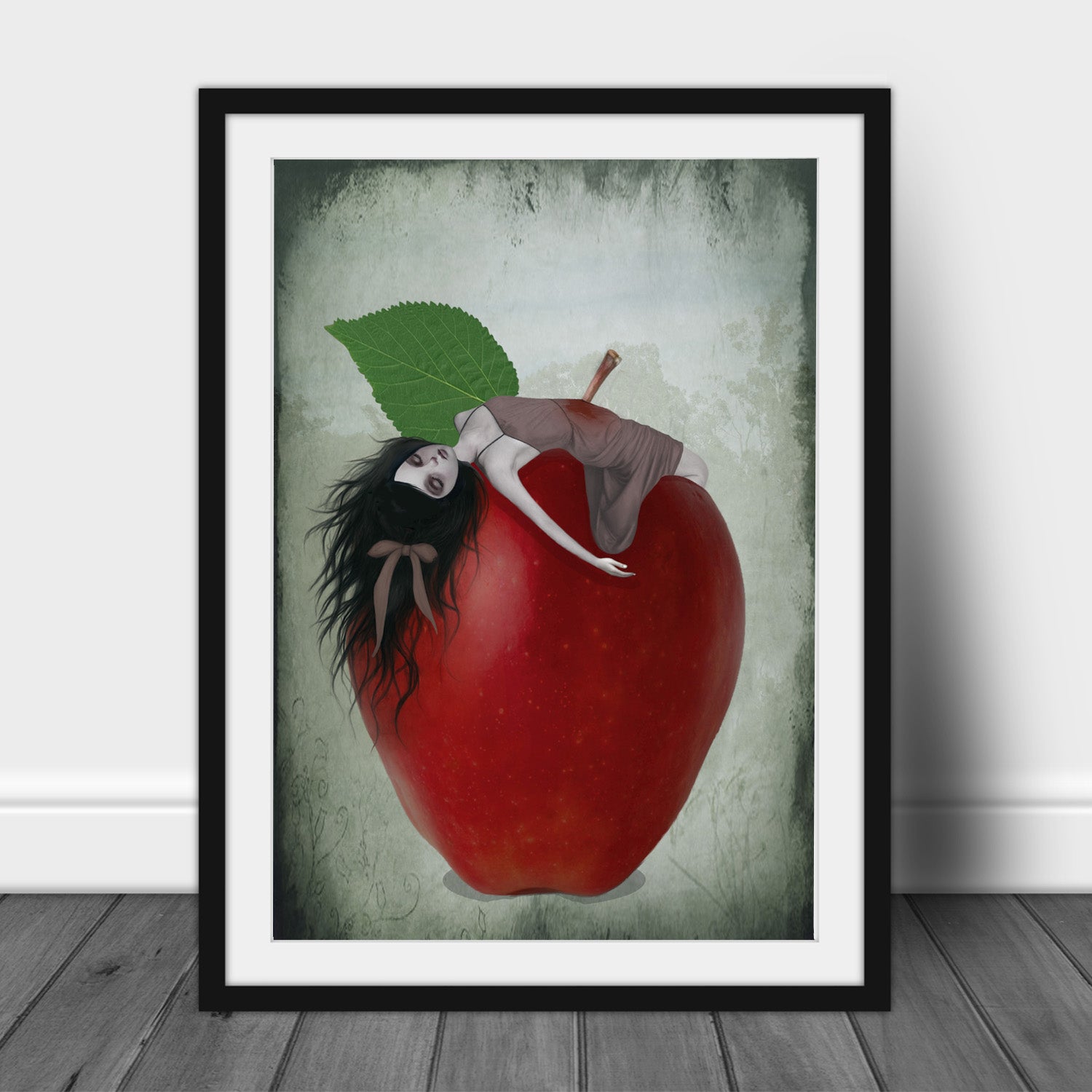 Framed artwork of Snow White impaled on the stalk of a red apple with a green leaf against a textured gray background.