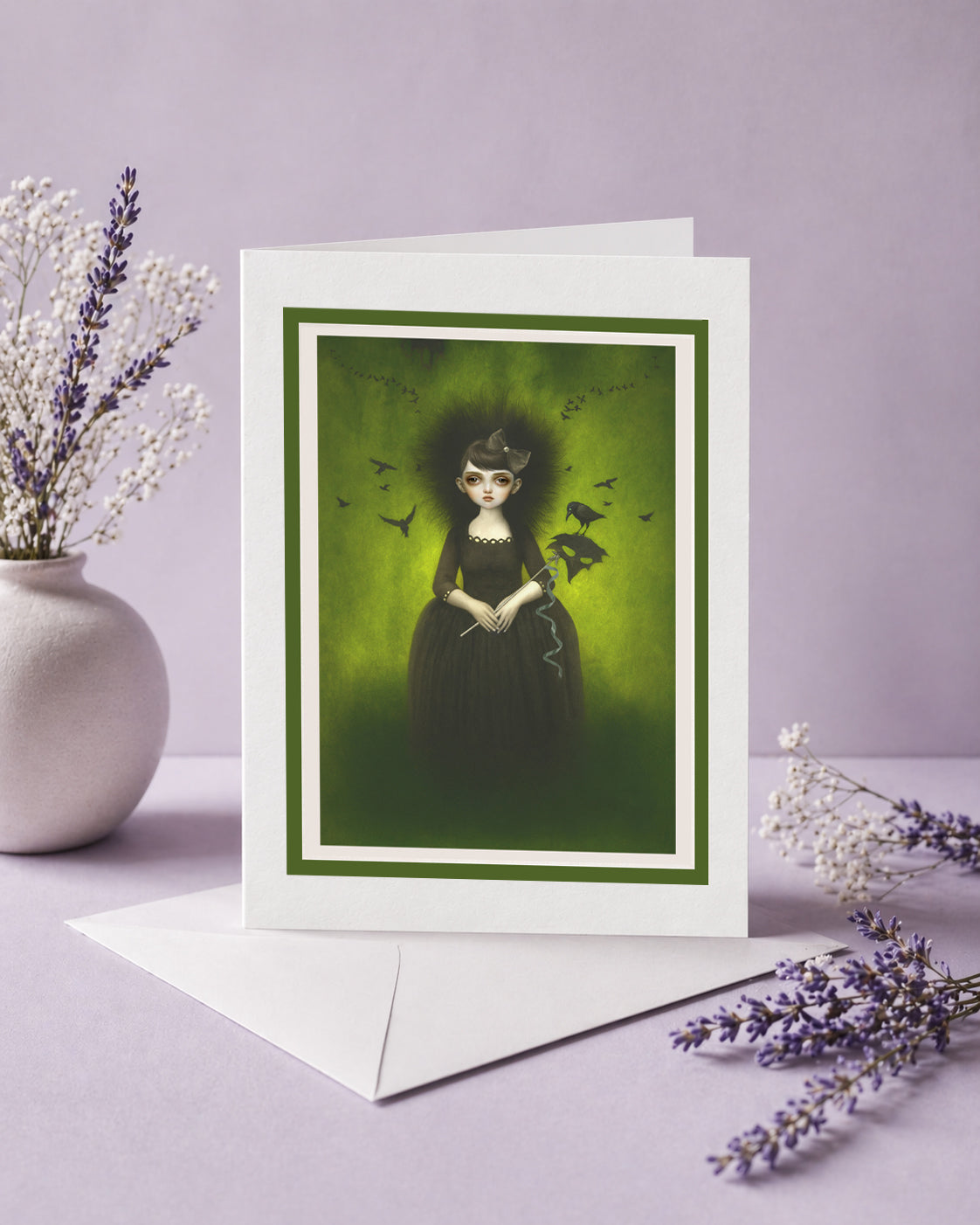 Greeting card with a dark-themed illustration of a goth girl and flock of crows on a purple surface with lavender flowers.