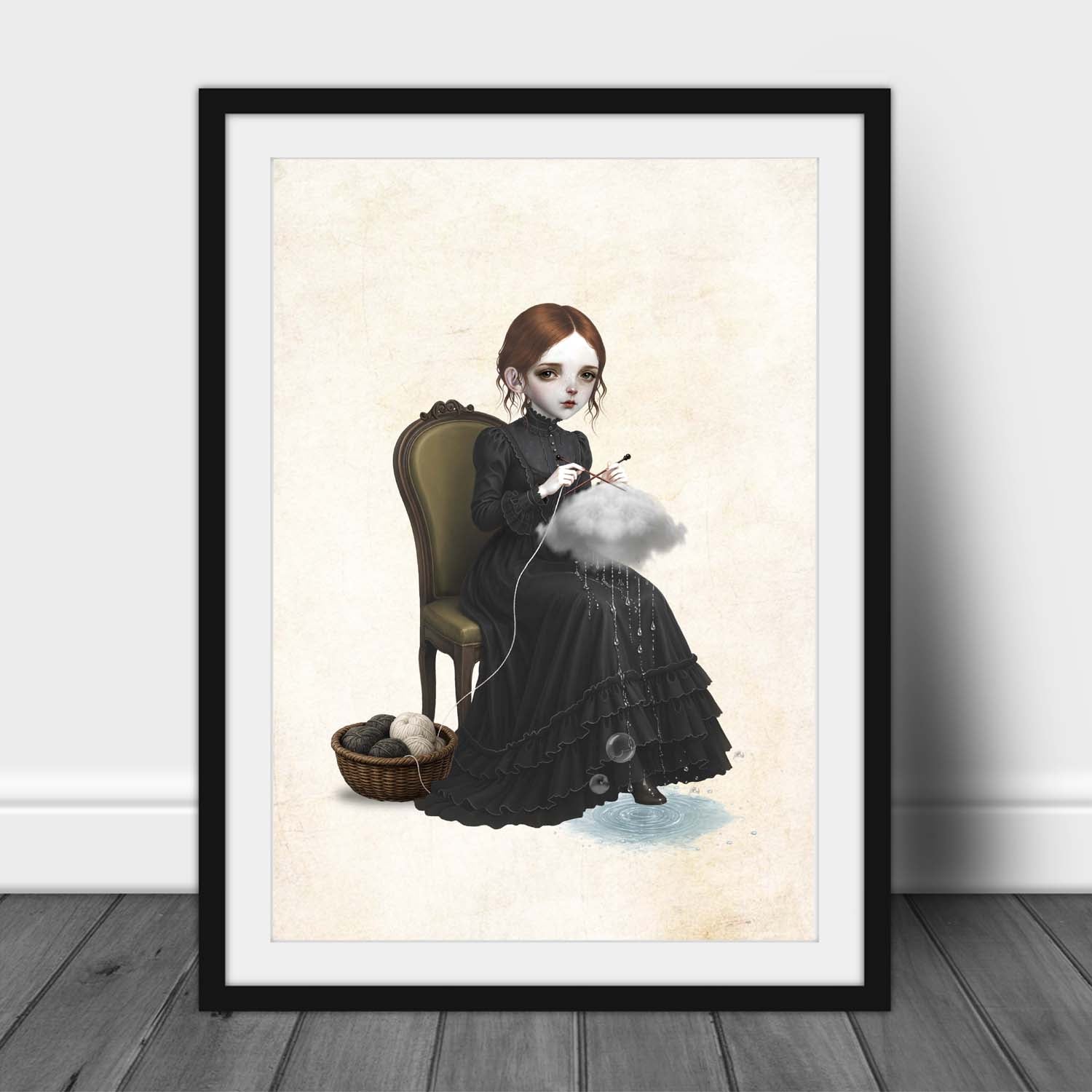 A dark whimsy pop surrealism art print in an A3 frame of a pale girl with brown hair in a black Victorian ruffled dress sitting on a vintage chair, using knitting needles to knit a grey rain cloud that drips water drops into a puddle at her feet next to a basket of yarn.