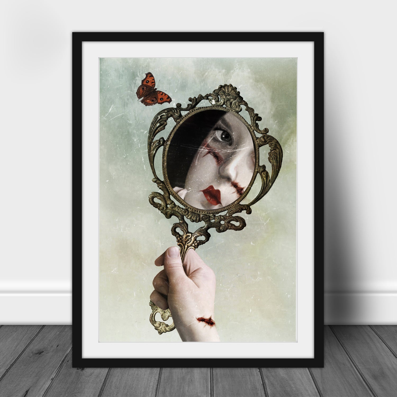 Dark surrealism gothic mirror art print in an A3 frame featuring a stitched portrait, vintage hand mirror and butterfly.
