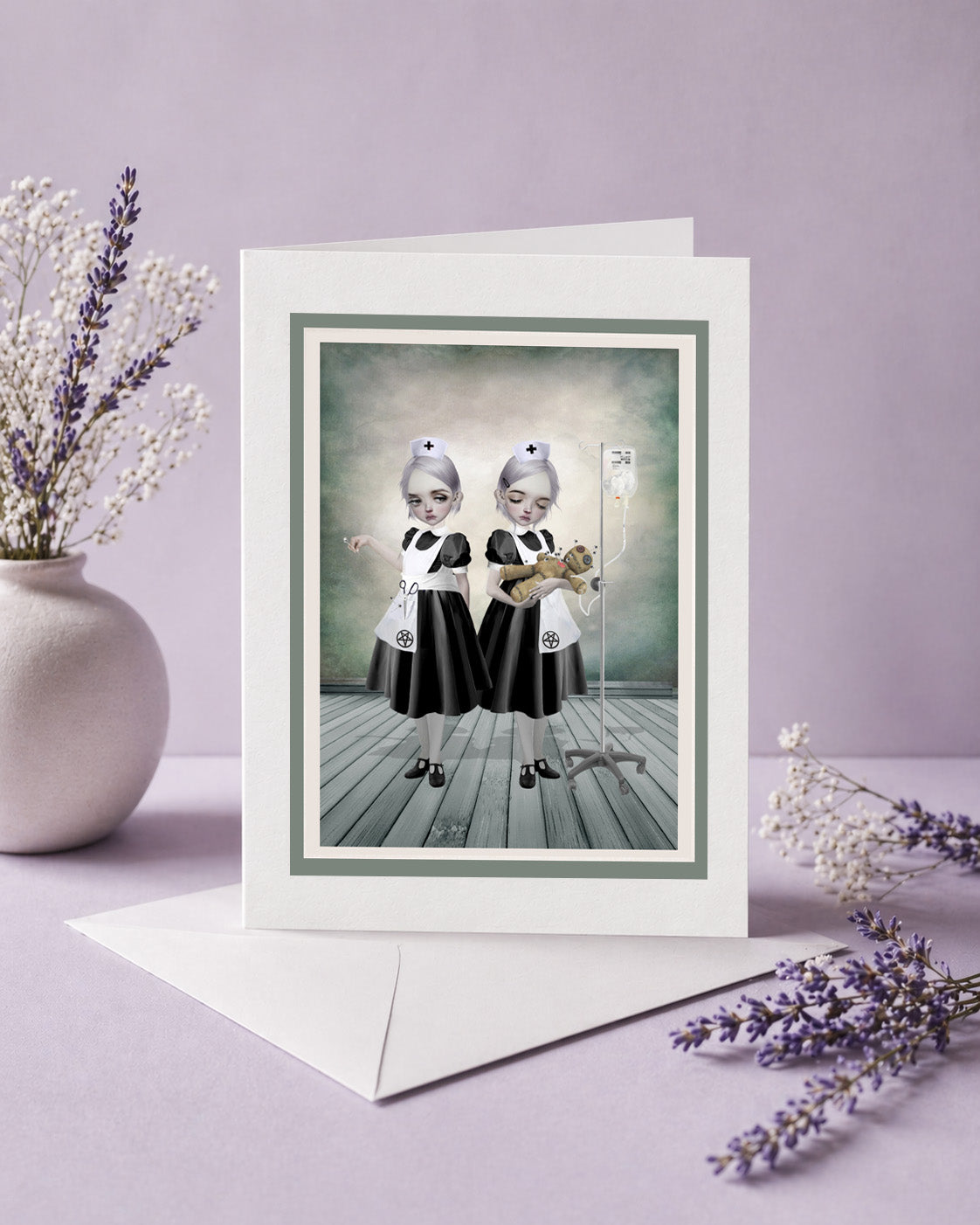 Gothic art greeting card with two identical nurses in black and white outfits with voodoo doll patient.