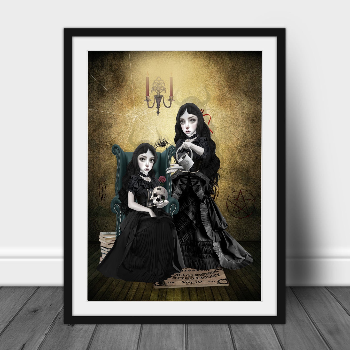 Art print of gothic sister witches at the witching hour, in a frame, leaned against a wall.