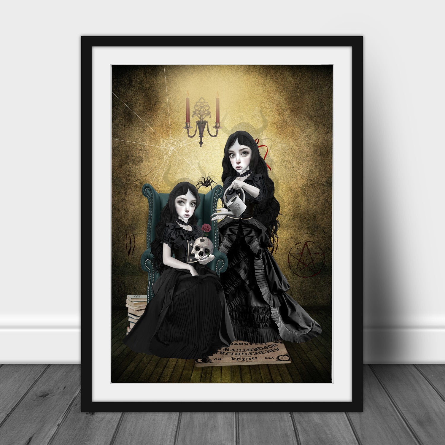 Art print of gothic sister witches at the witching hour, in a frame, leaned against a wall.
