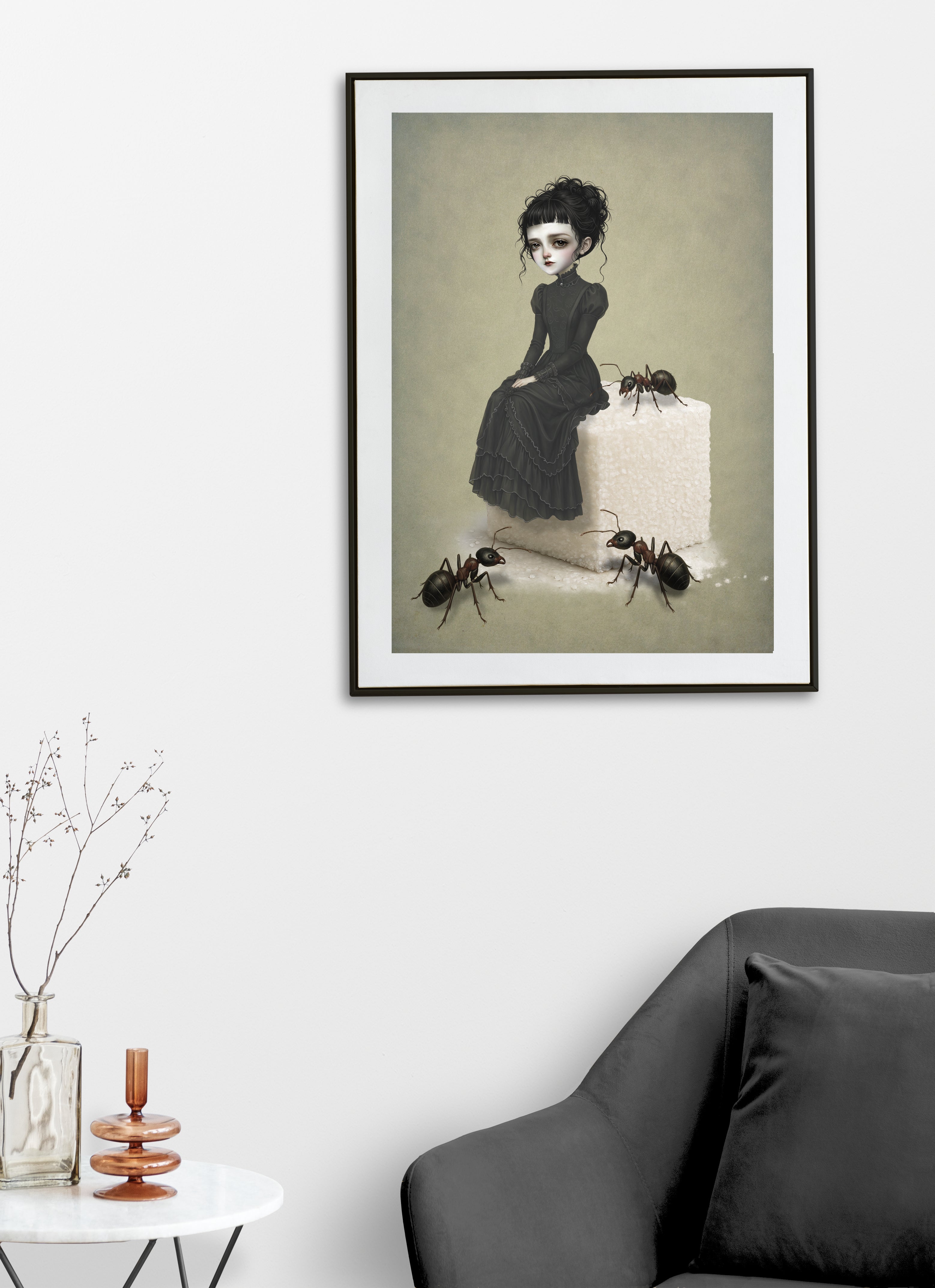A dark whimsy pop surrealism art print on a living room wall featuring a melancholy young woman in a black Victorian ruffled dress sitting on top of a giant white sugar cube, surrounded by three large, realistic ants on a muted green background.