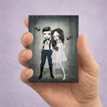 Hand holding an ACEO card with a dark, artistic illustration of a Vampire couple in a gothic setting.