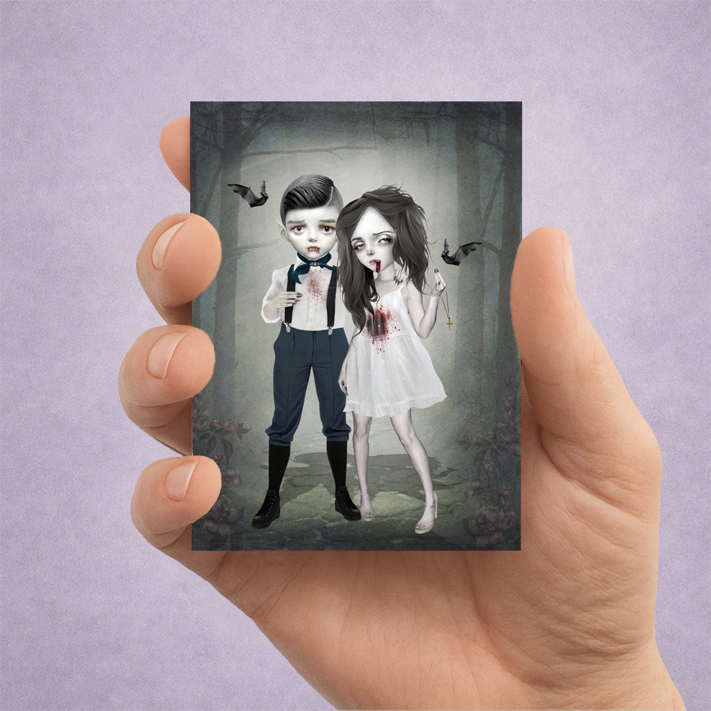 Hand holding an ACEO card with a dark, artistic illustration of a Vampire couple in a gothic setting.