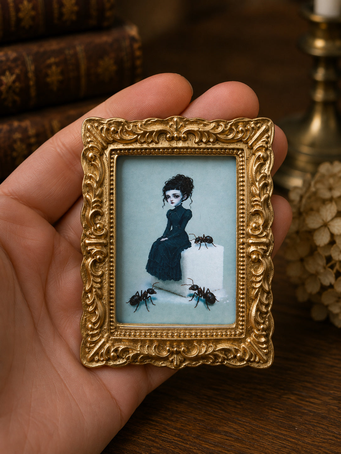 Gothic girl sitting on a sugar cube with giant ants miniature painting framed in vintage gold for 1:12 scale dollhouse wall decor.