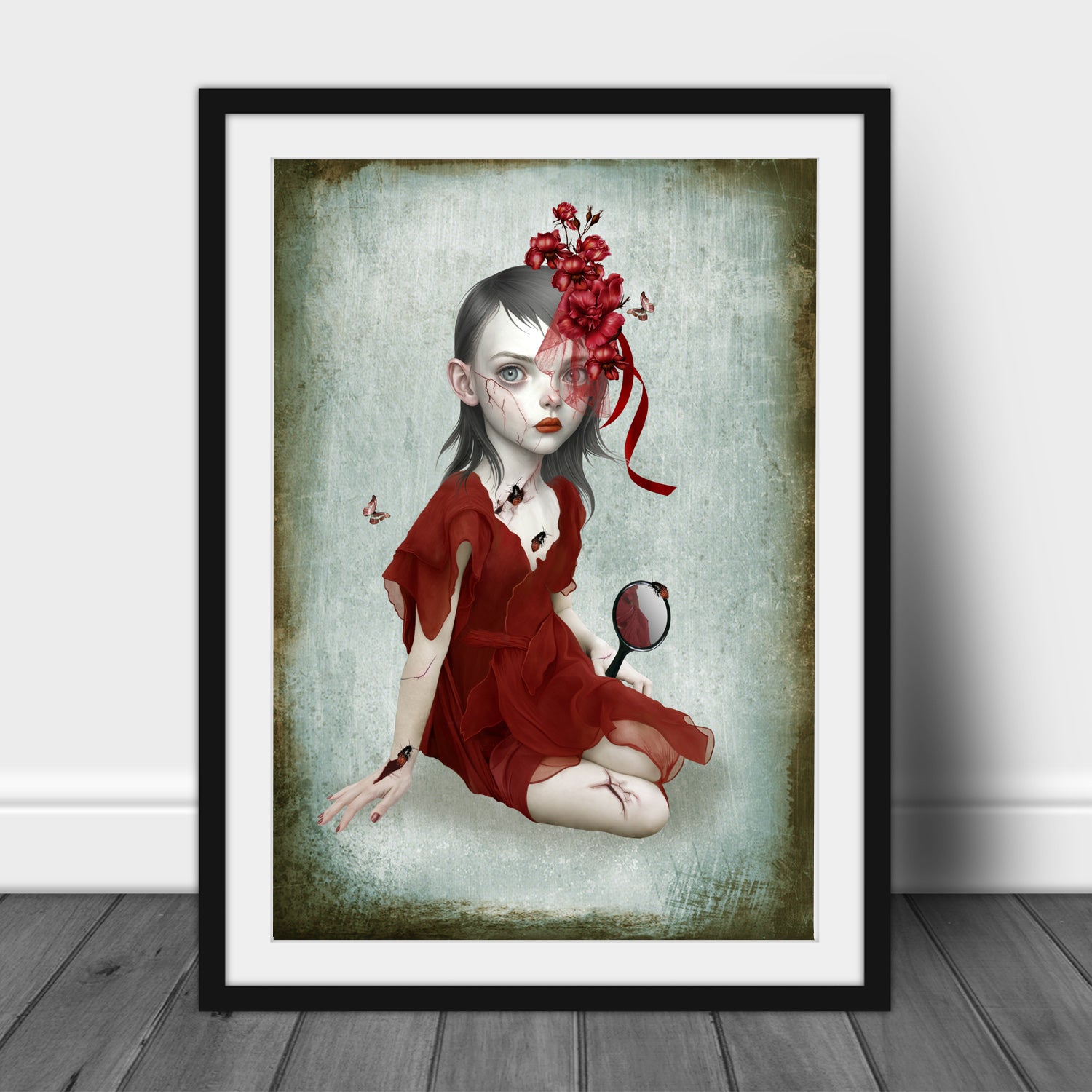 Framed artwork of a woman in a red dress with flowers on her head, sitting on the floor with a hand mirror, whilst bugs crawl from the cracks in her skin.