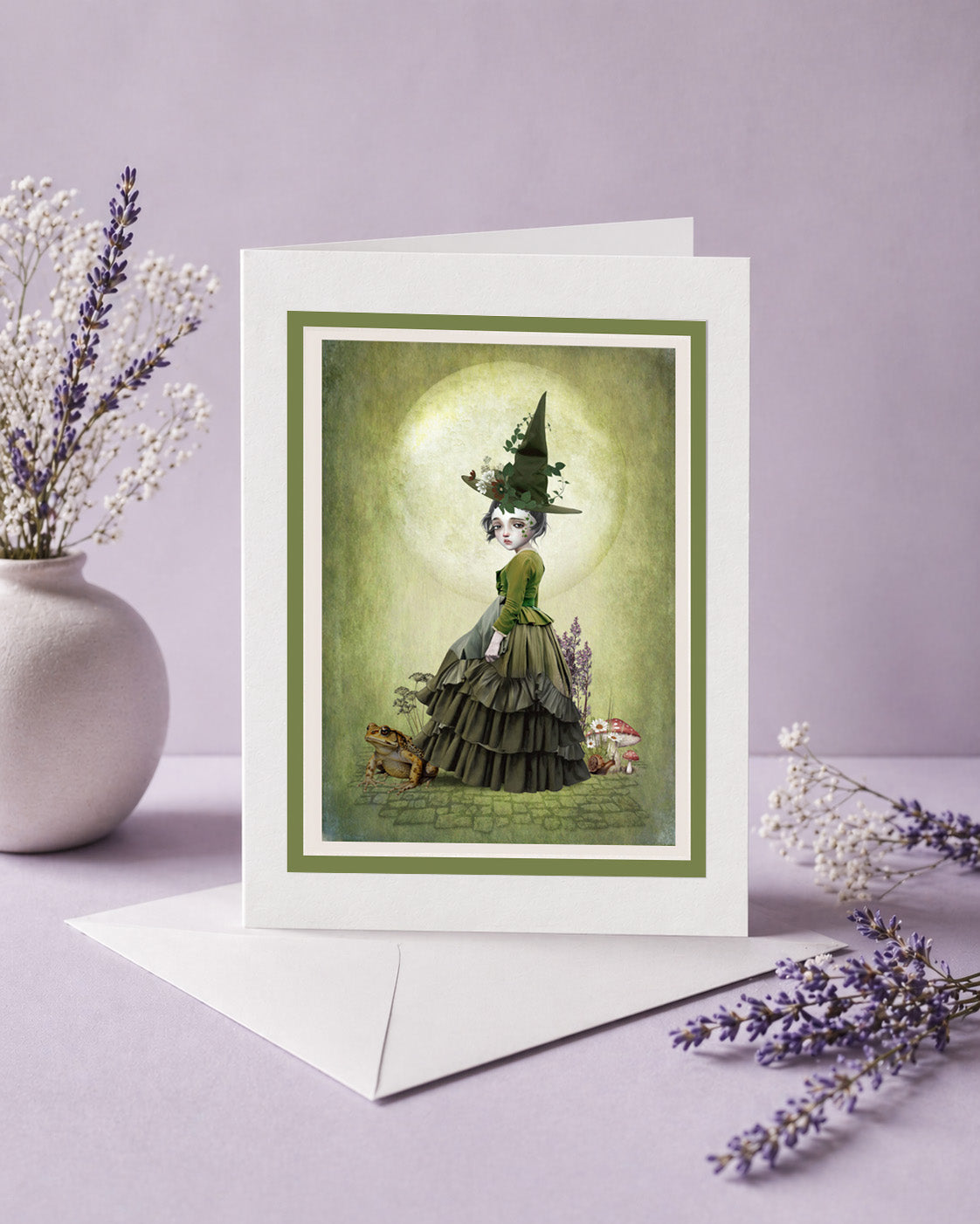 Green witch and toad art greeting card with a dark whimsical fantasy aesthetic.
