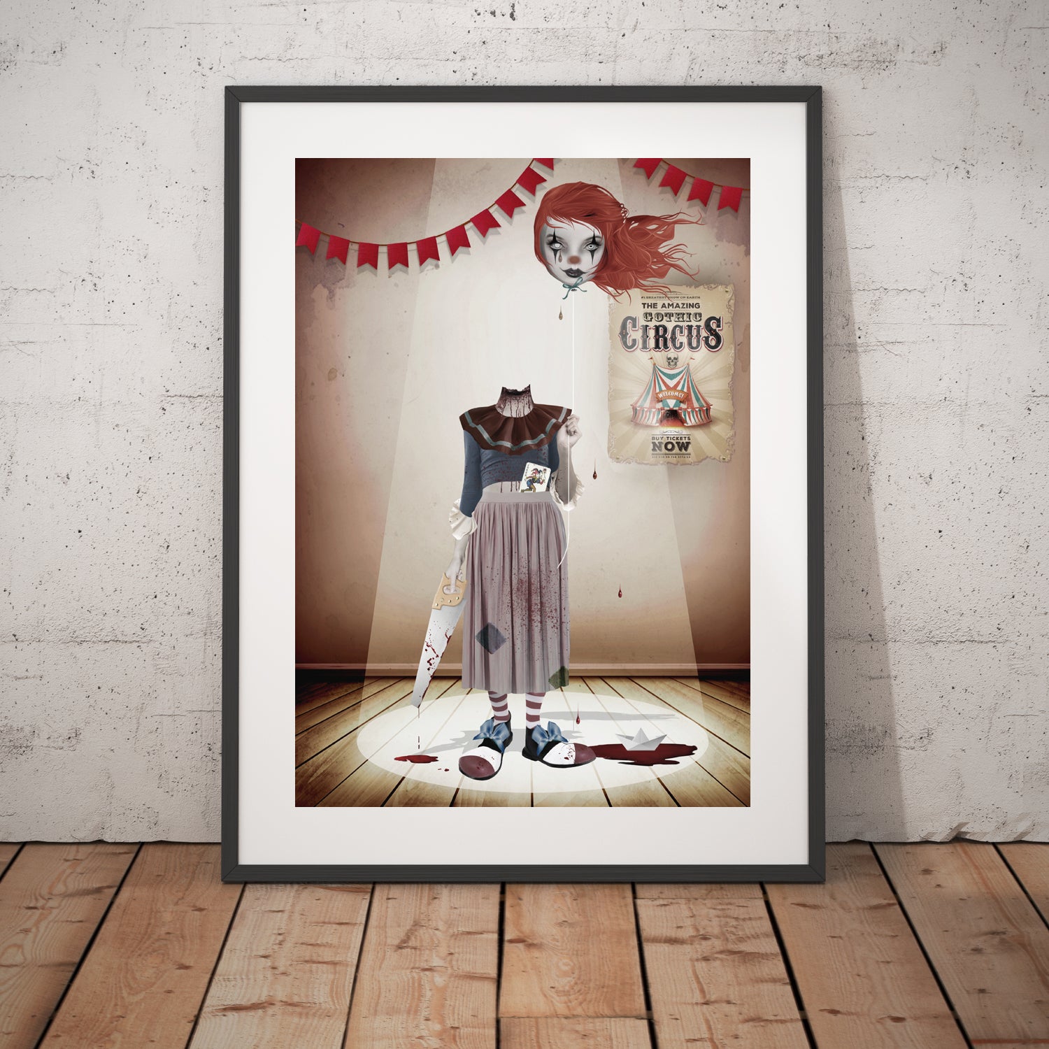 Headless Clown art print in a black frame, standing against a white wall.