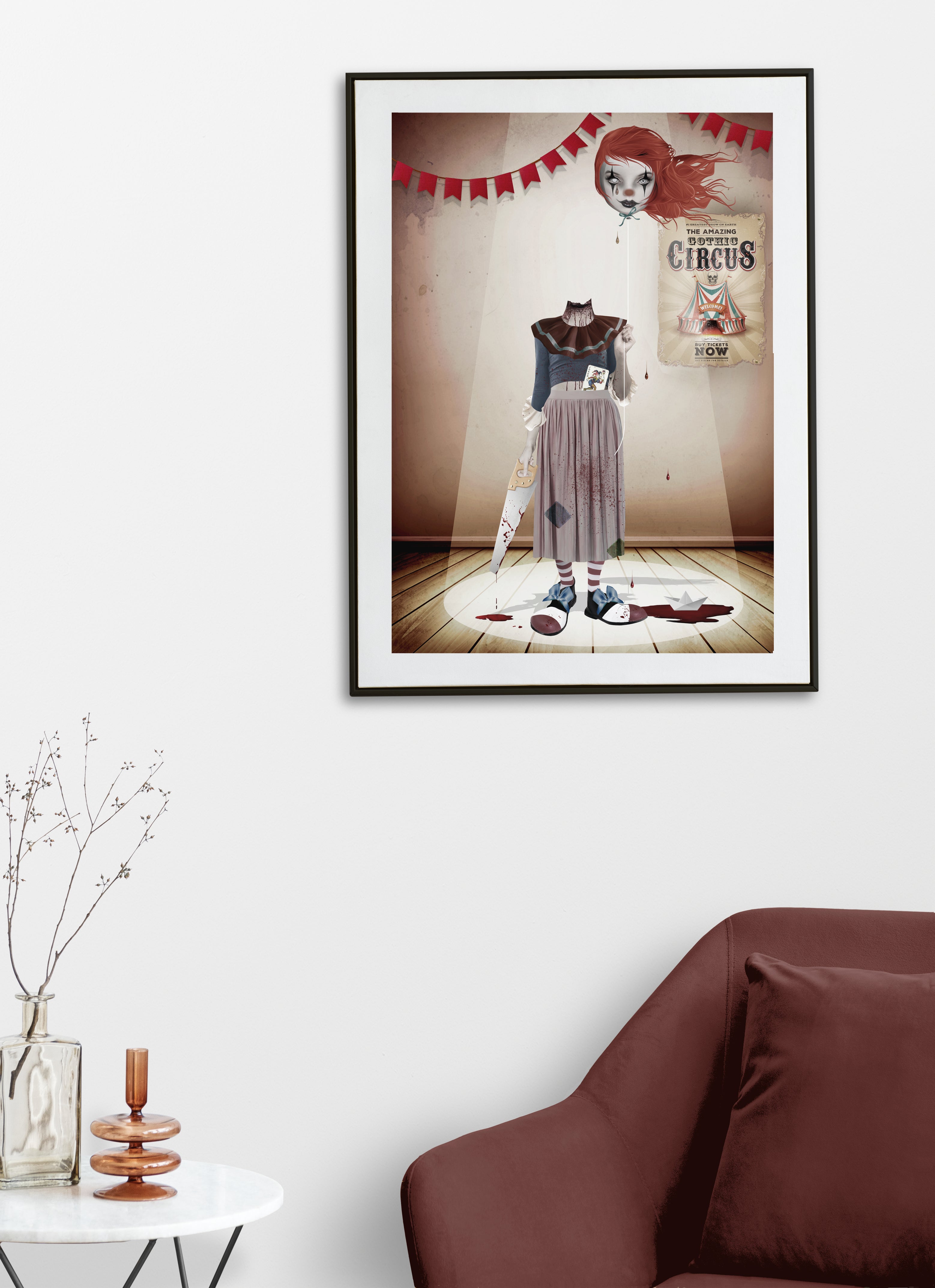 Framed artwork of a creepy headless clown with hand saw with a circus theme poster on a wall above a brown sofa.
