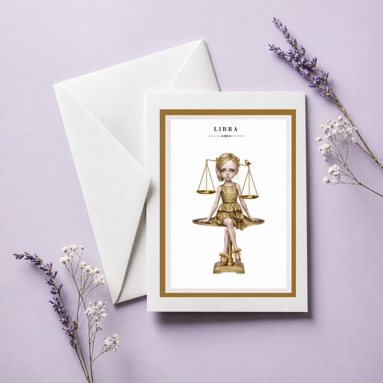 Libra zodiac birthday card and envelope featuring an illustration of a blonde maiden in a metallic gold dress sitting atop a golden balance scale with a tiny bird.