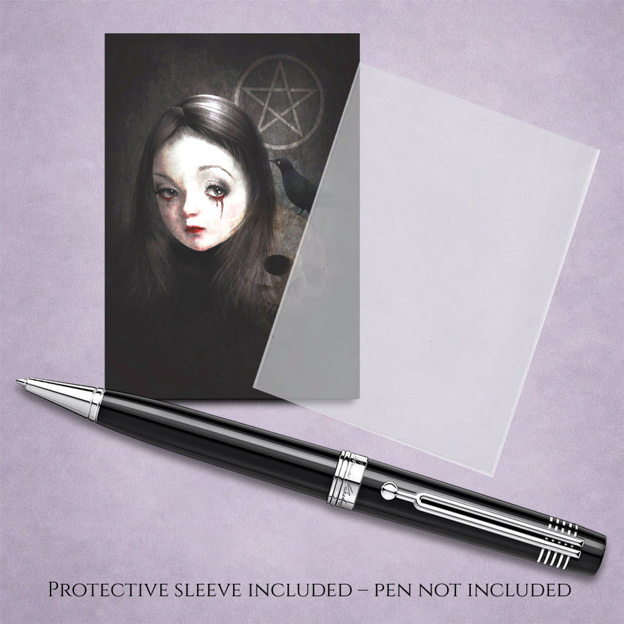 A gothic-style art print featuring a pale girl with dark hair and a pentagram symbol in the background, shown with a clear protective sleeve and a black and silver pen on a lavender background. Text at the bottom reads 'PROTECTIVE SLEEVE INCLUDED - PEN NOT INCLUDED'.