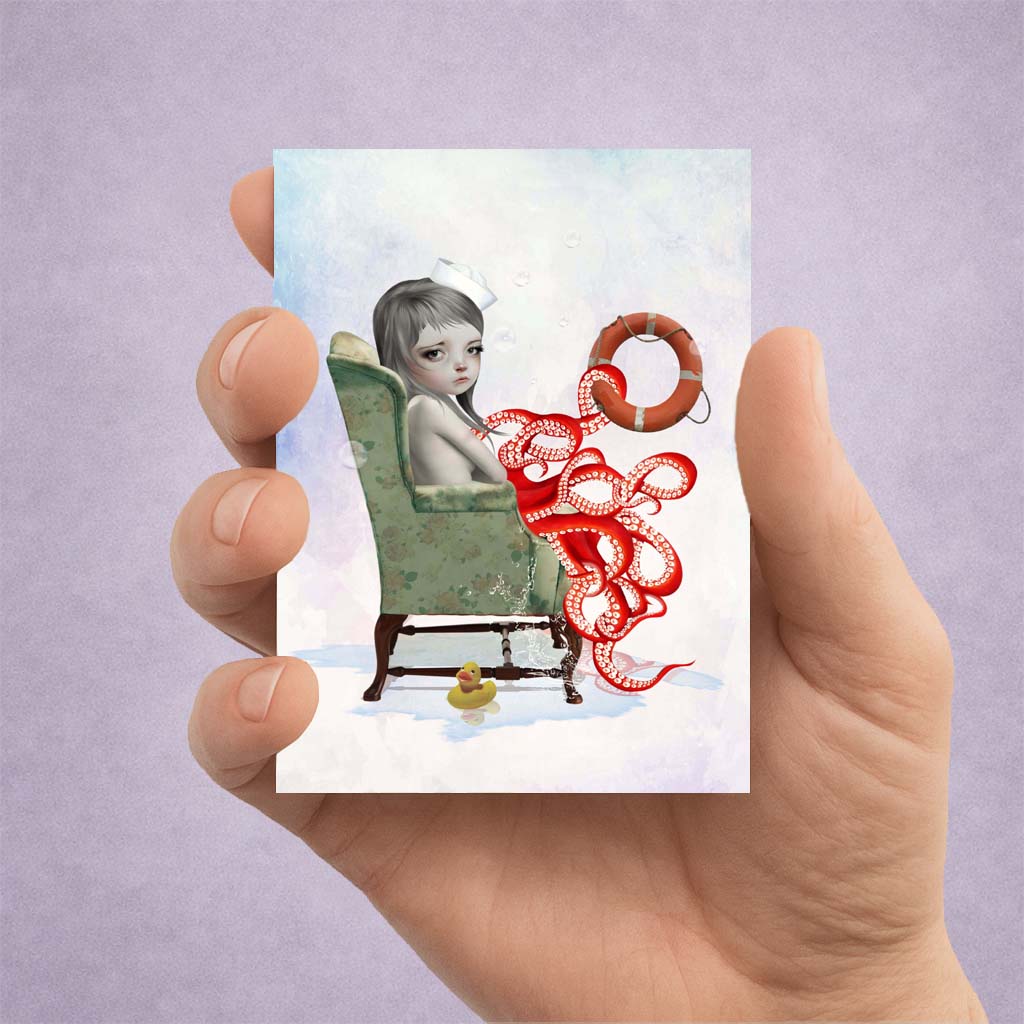 Hand holding an ACEO card with an illustration of an octopus girl in a chair, with a life buoy, and a rubber duck on a light purple background. 
