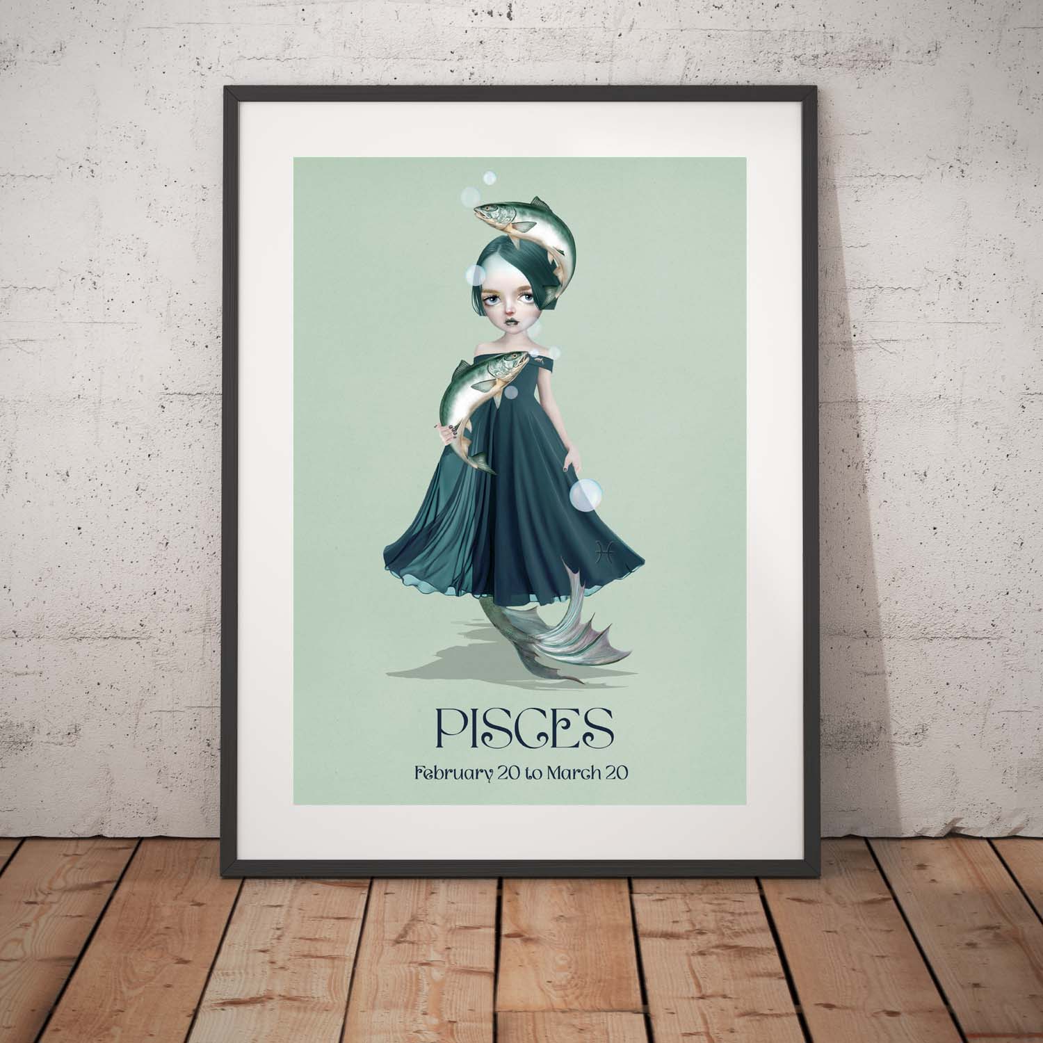 Pisces girl art print in a black frame, standing against a white wall.