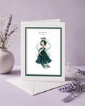 Pisces zodiac birthday card featuring an illustration of a dark-haired maiden in a deep teal dress with two fish and a mermaid tail, surrounded by splashing water.