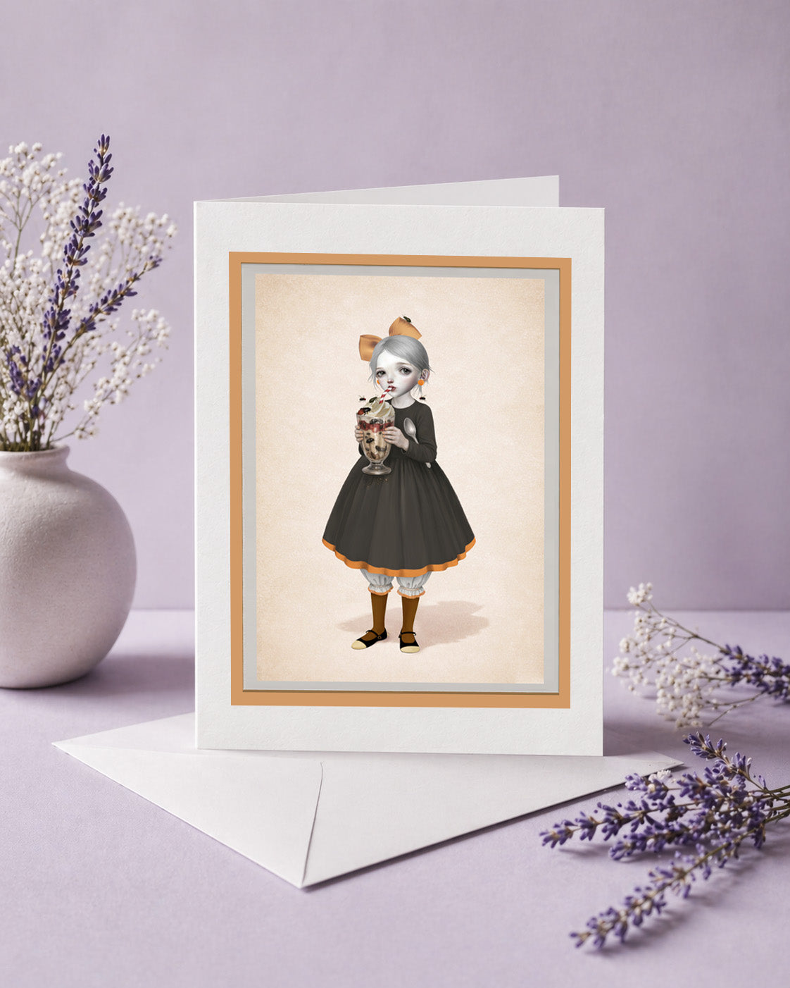 Greeting card with a strange illustration of a girl sipping on a sundae covered in beetles, placed on a light purple surface with decorative elements.