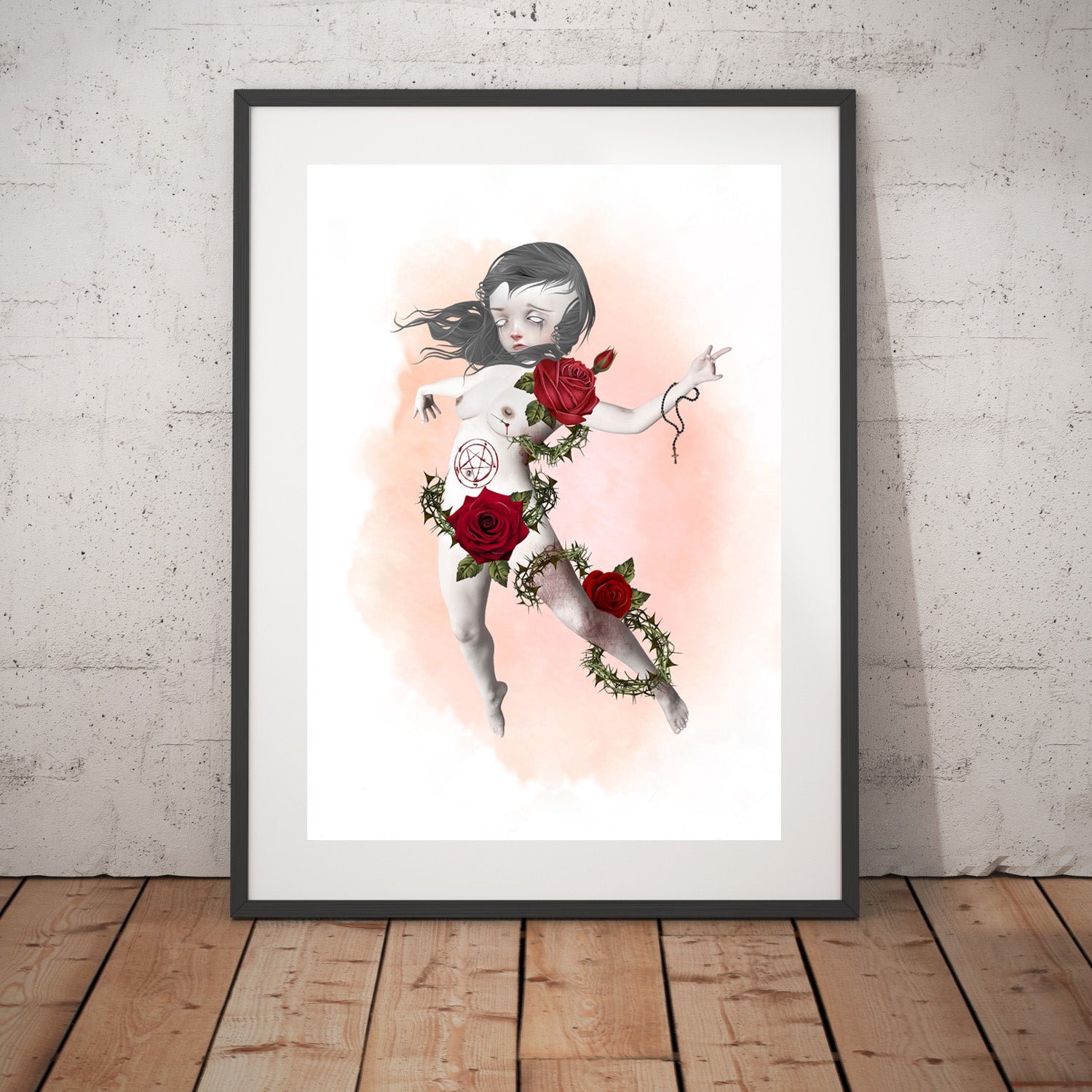 Posessed Girl enduring an exorcism art print in a black frame, standing against a white wall.