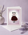 Blank creepy cute greeting card featuring a dark surrealism illustration of conjoined twins sewing. Includes a premium white envelope.