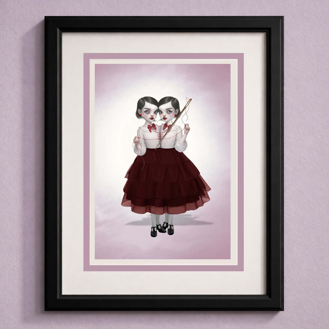 Framed creepy cute greeting card featuring a dark surrealism illustration of conjoined twins sewing.