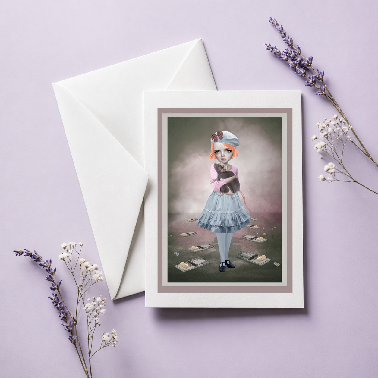 Greeting card with envelope. Card  illustration is of a girl holding an oversized rat, displayed on lilac background
