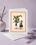 Greeting card with illustration of a girl and a venus flytrap on a light pink background, surrounded by lavender flowers.