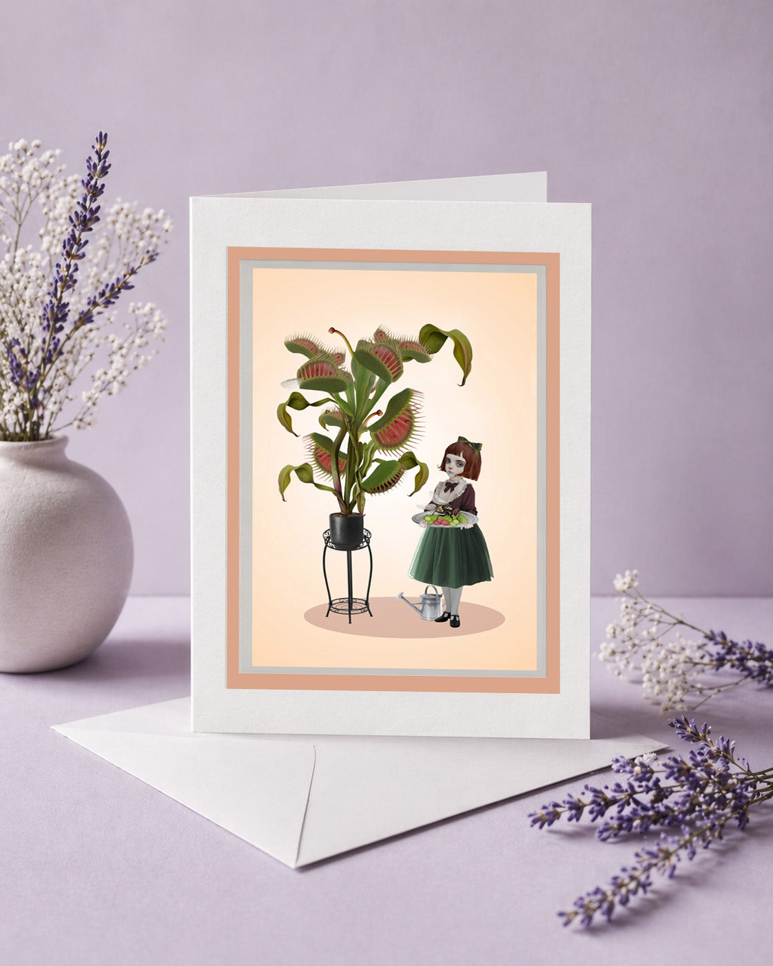 Greeting card with illustration of a girl and a venus flytrap on a light pink background, surrounded by lavender flowers.
