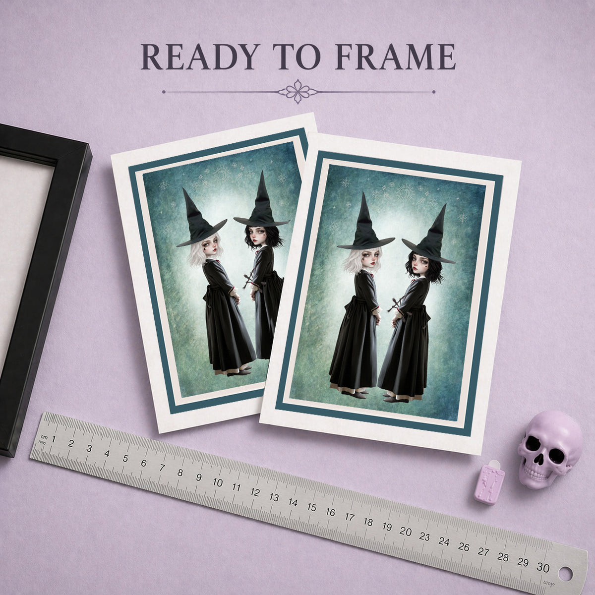 Ready to frame gothic art greeting card featuring twin witch sisters in black pointed hats standing back to back against a celestial teal background.