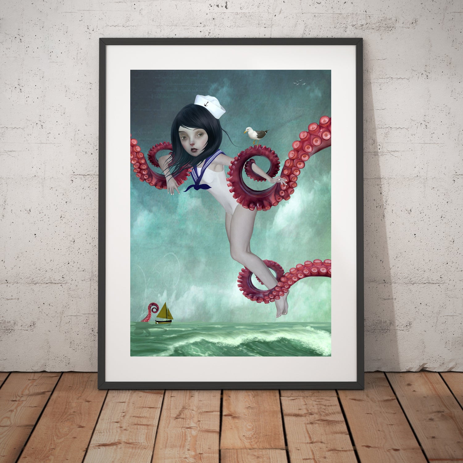 Surreal art print of a sailor girl surrounded by octopus tentacles, displayed in a large black frame, leaning against a white wall.