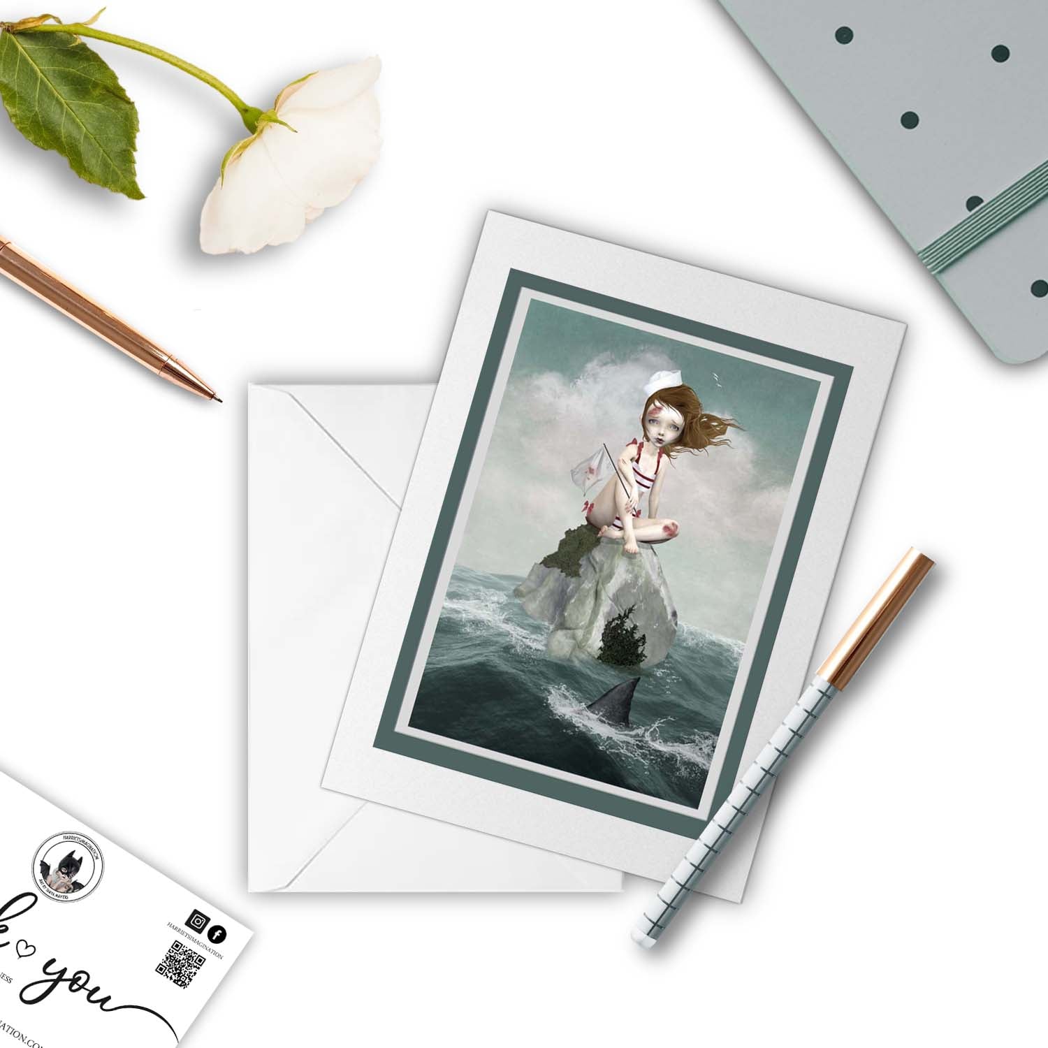 Shark infested waters greeting card beside a notebook and pen – perfect for gifting or writing a whimiscal, poetic note.