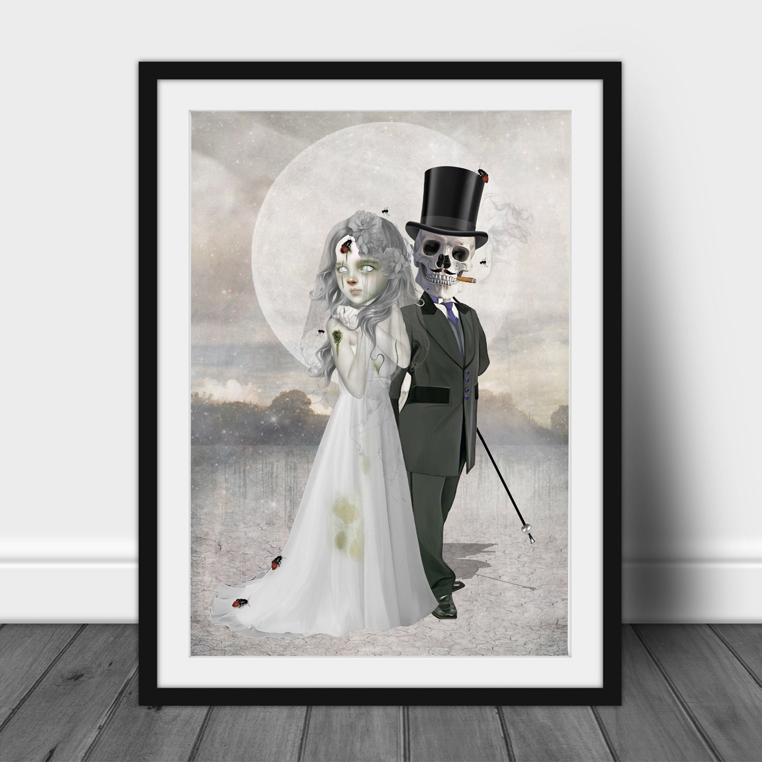 Framed artwork of a bride and groom skeleton couple against a cloudy sky.