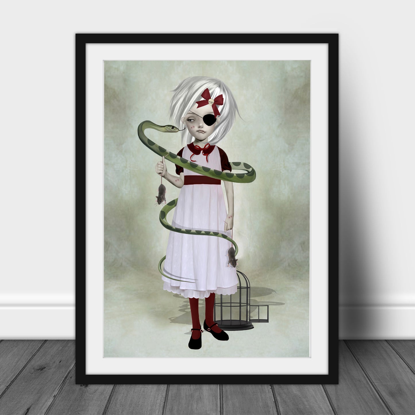 Art print of a girl and snake, in a frame, leaned against a wall.