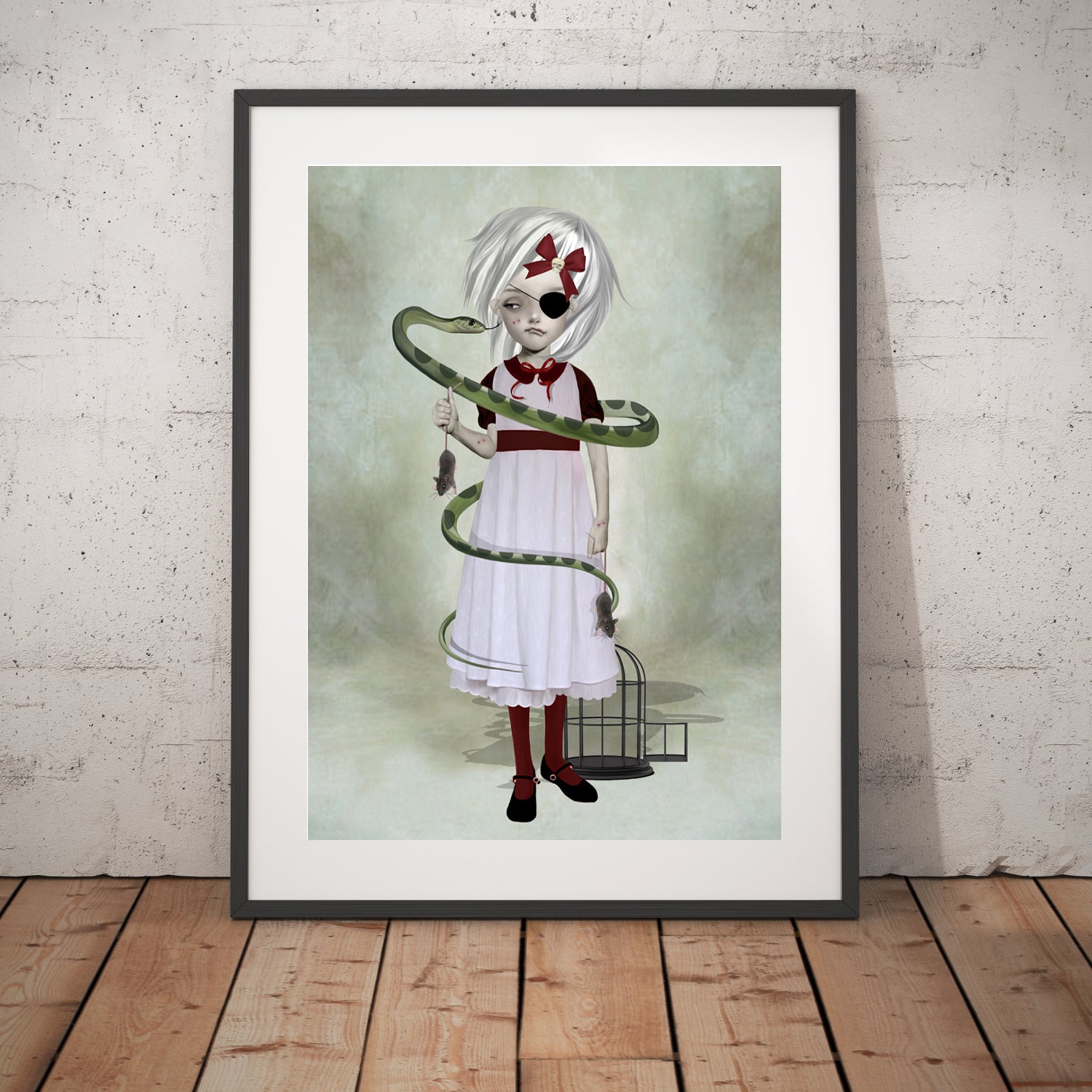 Girl and her pet snake art print in a black frame, standing against a white wall.