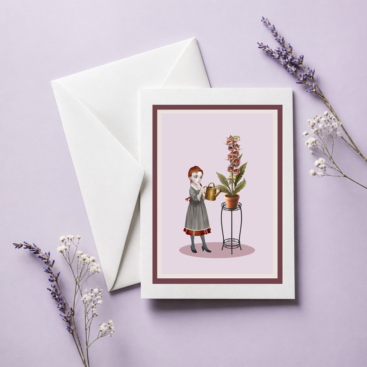 Art greeting card with illustration of a girl watering her foxglove plant with real foxes heads, accompanied by a white envelope on a light purple background.