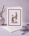 Greeting card with illustration of a girl watering foxglove plant with real fox heads on a purple background