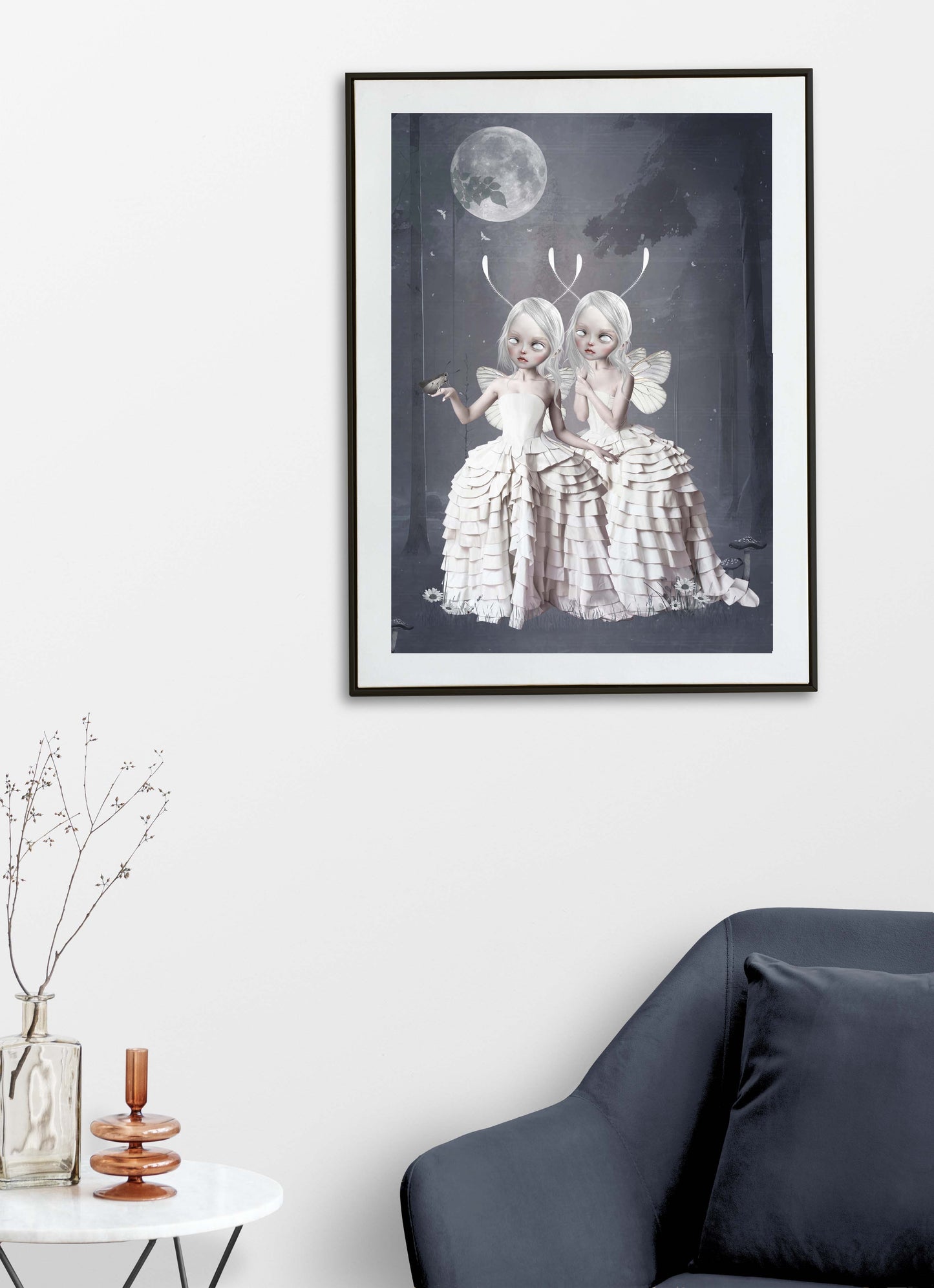 Surreal art print on living room wall, image is  two Moth girls in an enchanted forest, with a moth gently landing on one moth girl's hand.