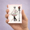 Surreal Skeleton ACEO Art Card held in hand to display size.