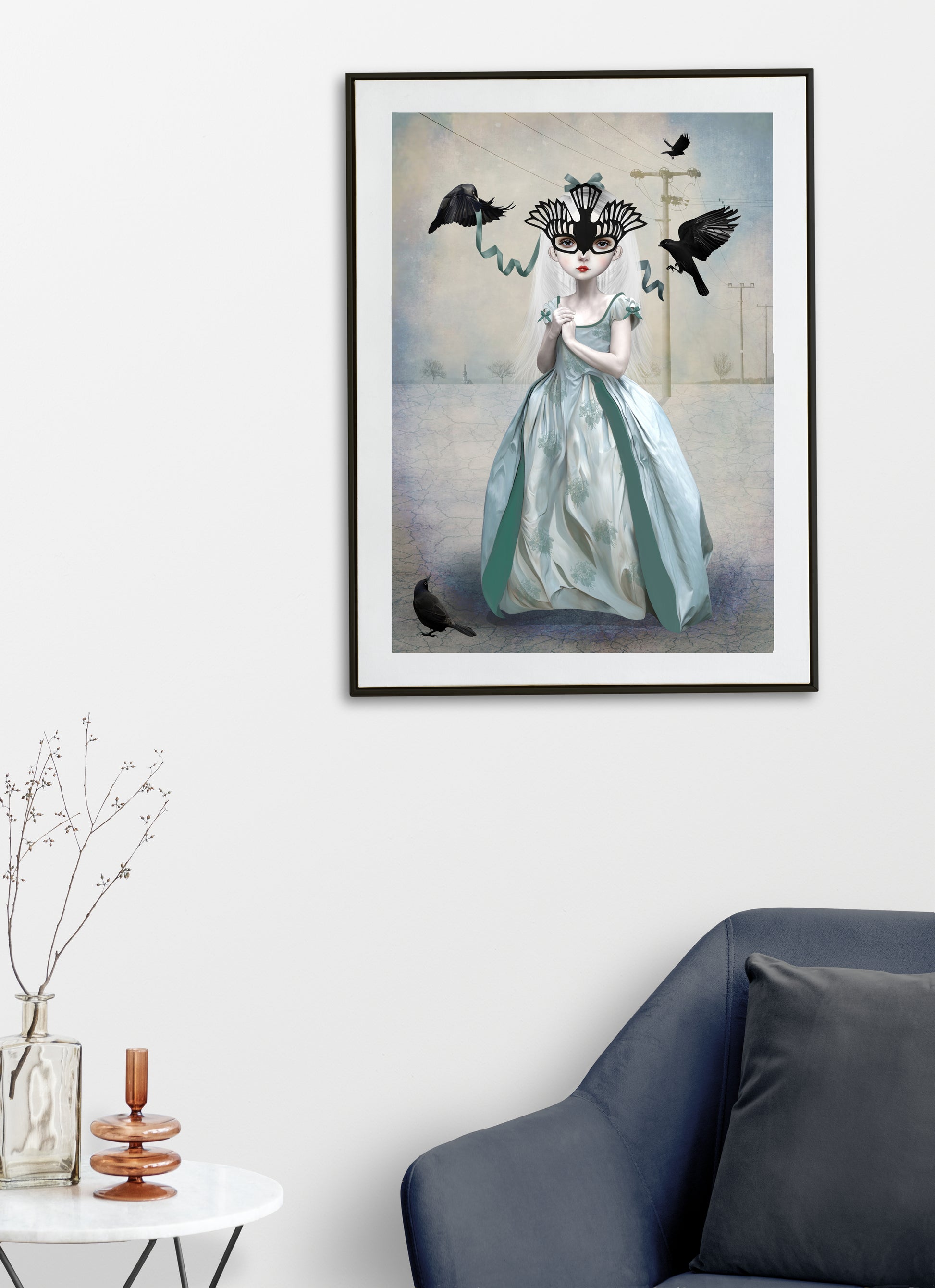  Framed blackbird art print on living room wall featuring a girl in a blue gown adorned with a blackbird mask surrounded by blackbirds. 