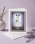 Surrealist Mouse Girl" art greeting card. Featuring a striking pop-surrealist illustration of a wide-eyed girl with mouse ears, this card perfectly blends creepy-cute charm with gothic fairytale undertones.