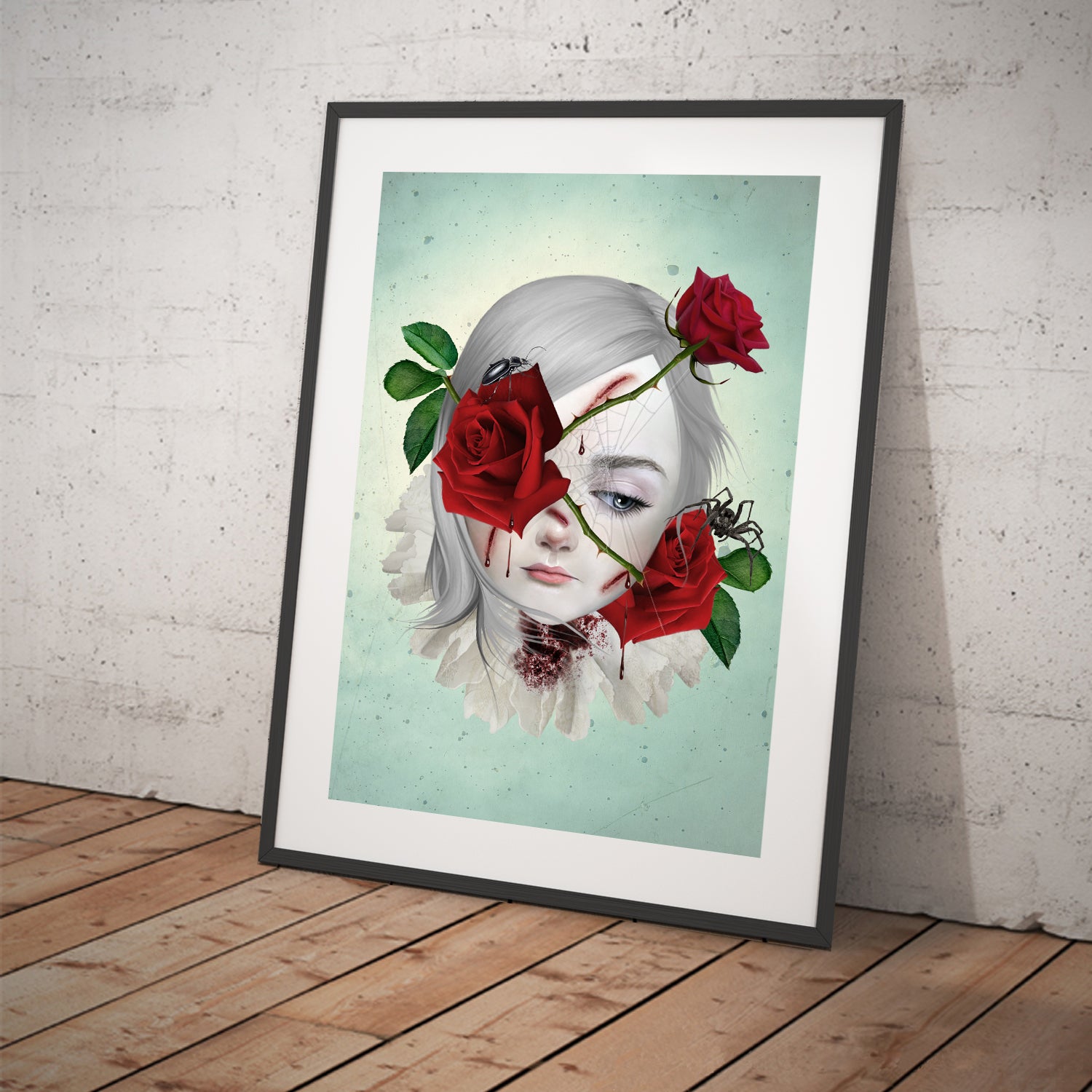 Surreal art print of a girl with thorny red roses bleeding from the thorns, surrounded by a spider and beetle, displayed in a large tilted black frame. This emotional dark fantasy artwork conveys depth and symbolism.