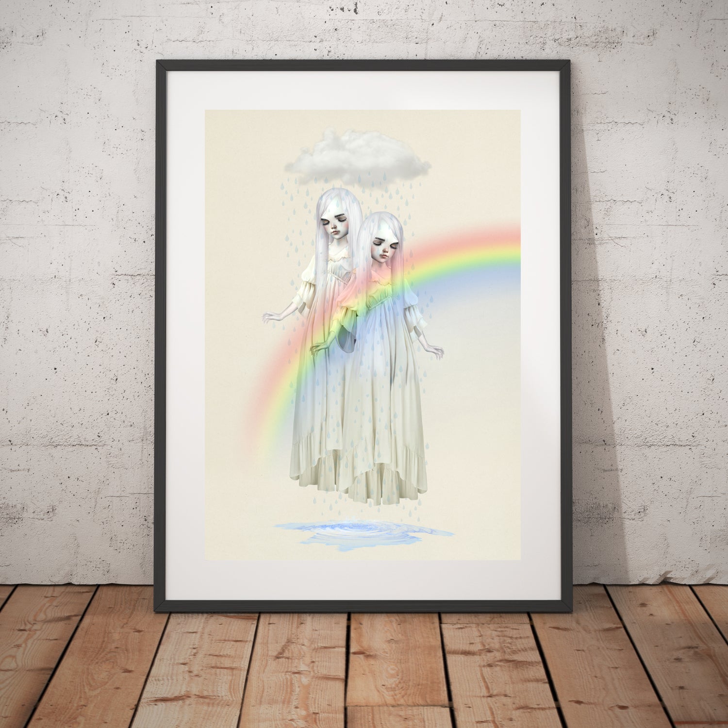 Twin girls beneath a rain cloud art print in a black frame, standing against a white wall.