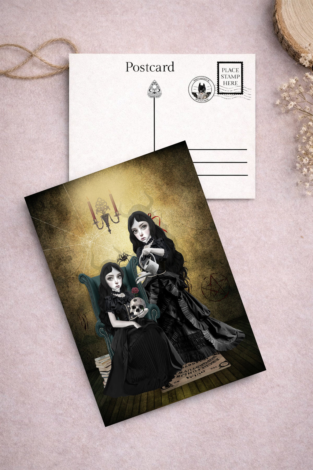 Gothic-themed postcard with two goth sisters in black dresses and a skull, and ouija board.